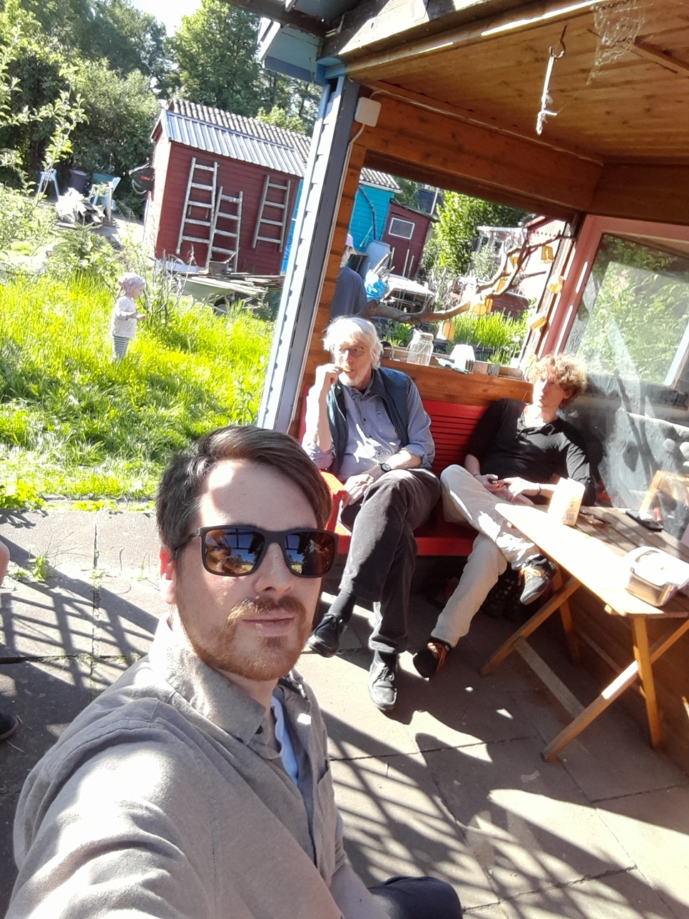 Friedemann im Kleingarten mit Vater und Bruder an einem sommerlichen Tag.